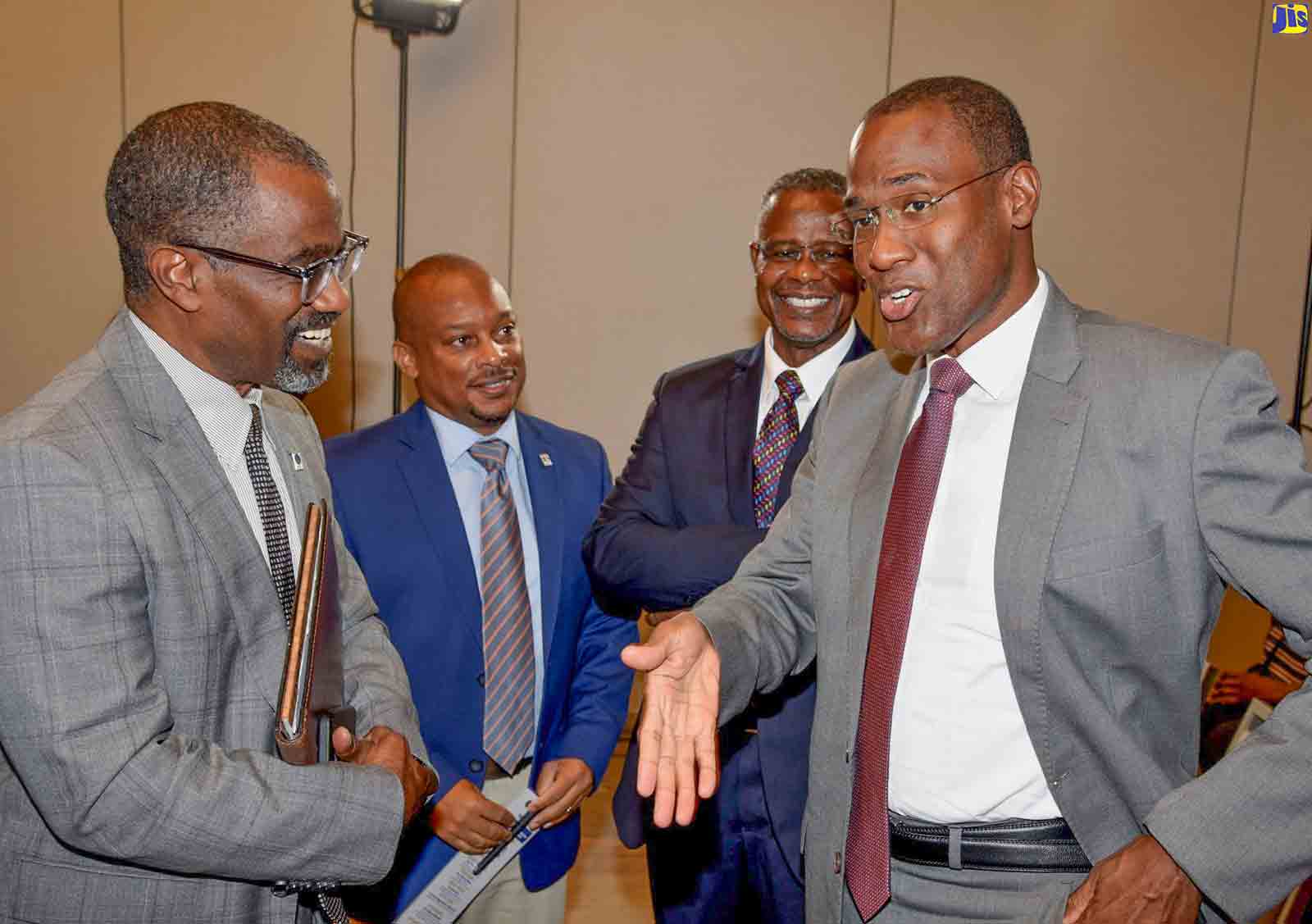 Minister of Finance and the Public Service, Dr. the Hon. Nigel Clarke (right), converses with Development Bank of Jamaica (DBJ) Managing Director, Anthony Shaw (left), during Thursday’s (August 11) launch of the entity’s Entertainment and Transport Sector Loan products, at the AC Marriott Kingston Hotel. Sharing in the discussion are General Manager for DBJ’s Channels, Relationship and Marketing Division, Edison Galbraith (second left); and DBJ Manager for Investor Relations, Paul Chin. 