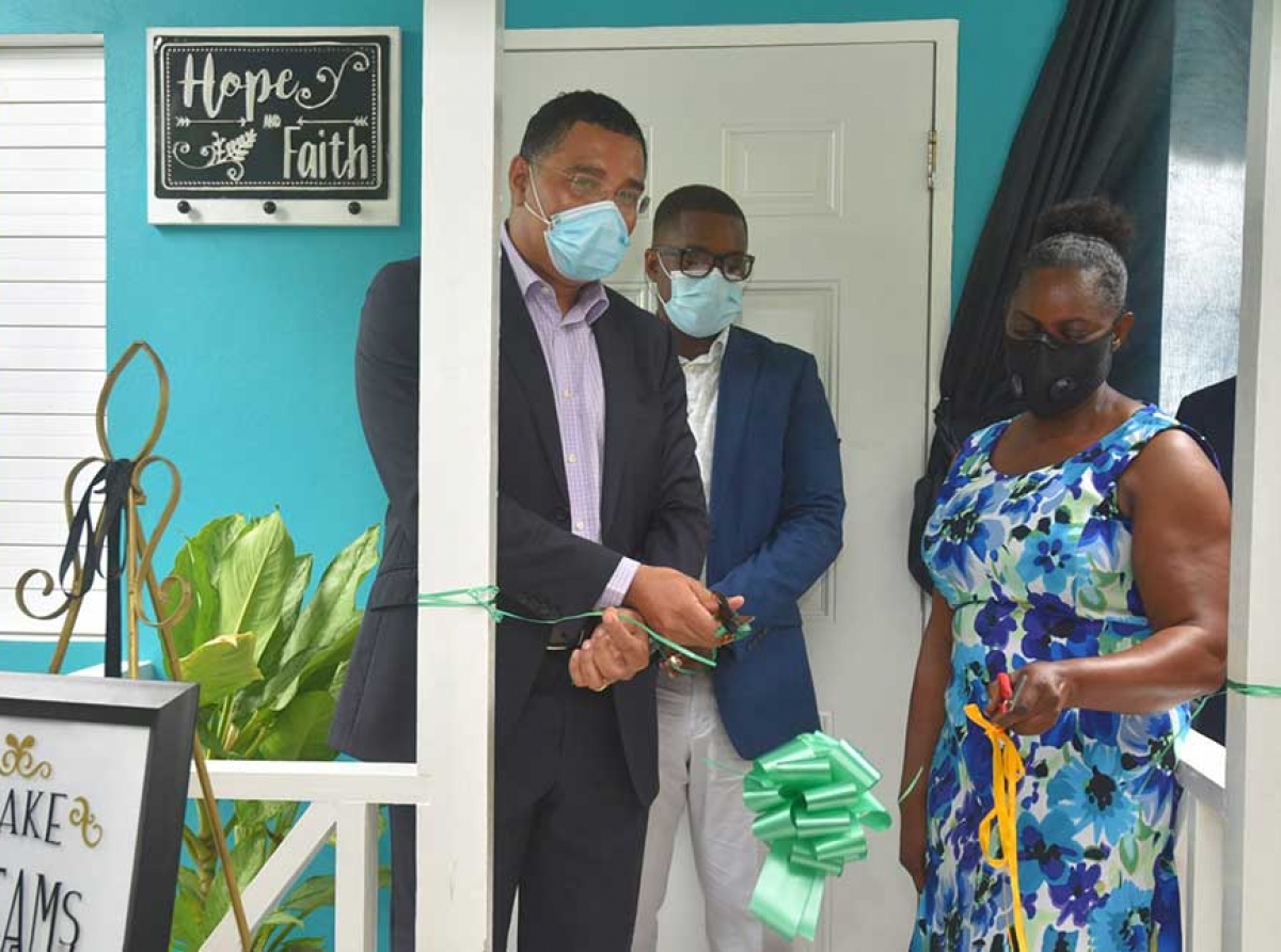 Prime Minister, the Most Hon. Andrew Holness (centre), in discussion with Julie Ann Sterling (left), recipient of a $9-million housing solution under the social housing programme in Salt Spring, St. James Central, on May 21. The Prime Minister was touring the house with Ms. Sterling after handing over the unit. Sharing the moment at right is Permanent Secretary in the Ministry of Economic Growth and Job Creation, Audrey Sewell.|JIS photo 