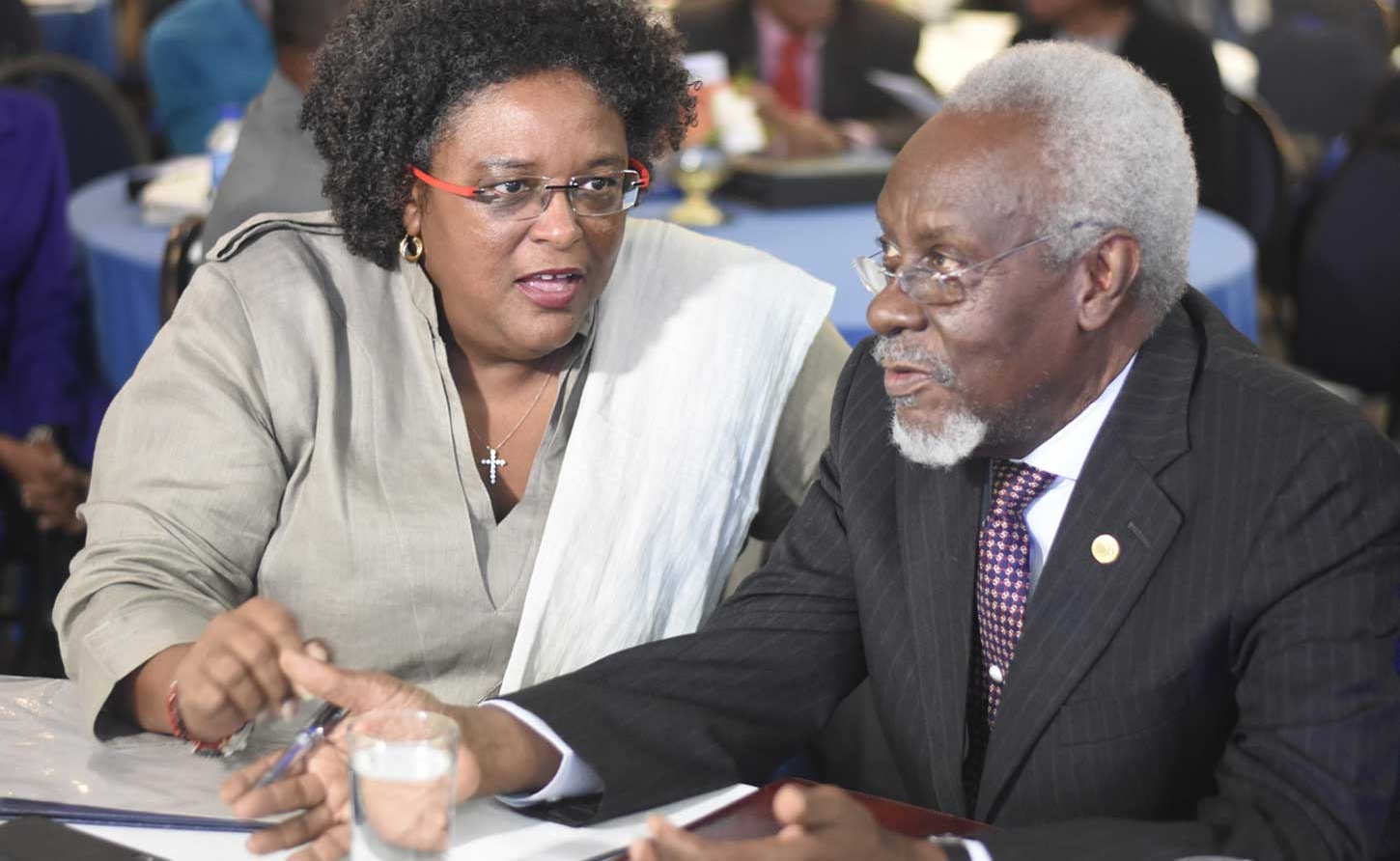 Former Jamaican Prime Minister PJ Patterson listens as Barbados Prime Minister Mia Mottley  as she makes a point at a recent Regional Investments and Capital Markets Conference.