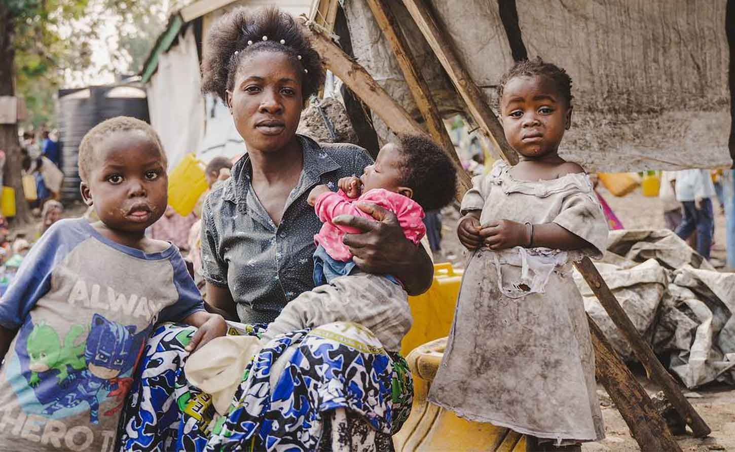 UNICEF/Jospin Benekire A displaced family sit in front of their makeshift shelter in Goma, North Kivu province, DR Congo.