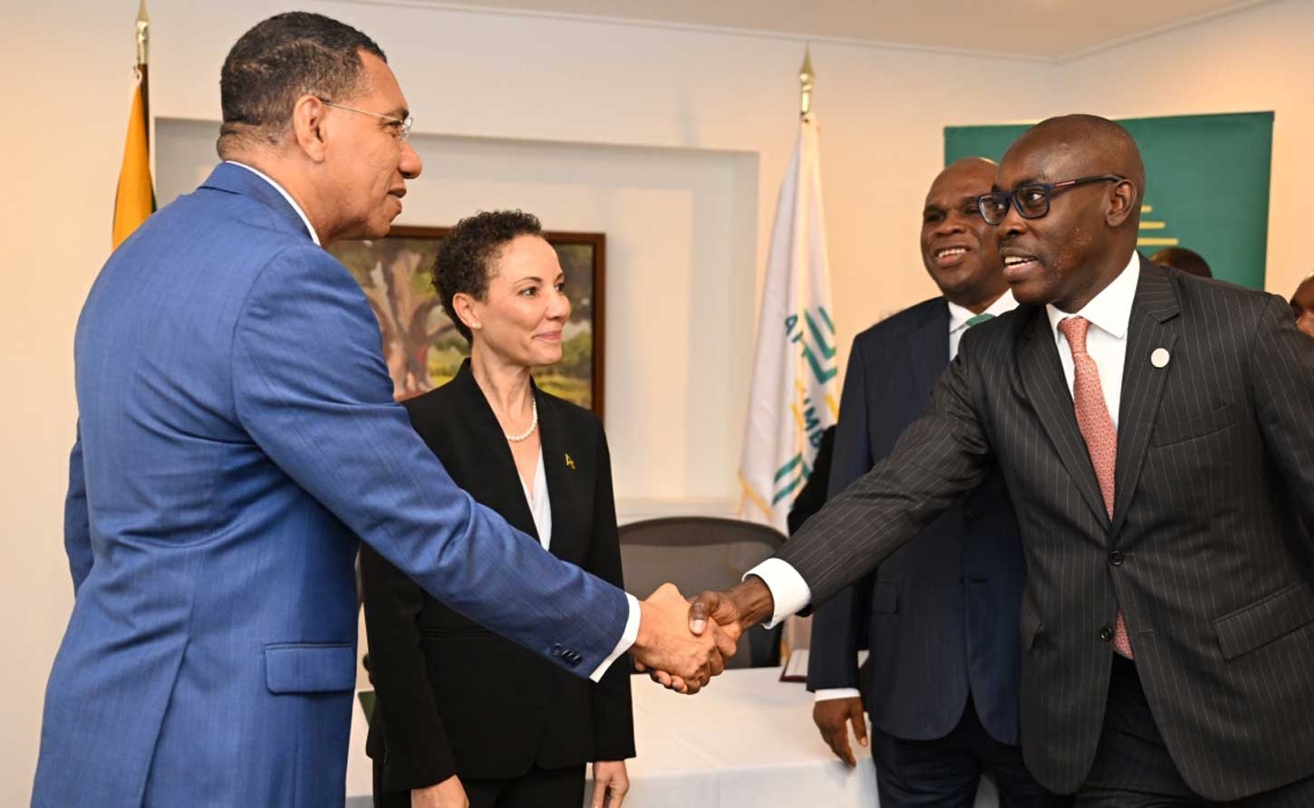 Prime Minister Andrew Holness greets Afreximbank's Acting Chief Operating Officer of the Caribbean Office Okechukwu Ihejirika at the signing of a MOU with the Afreximbank at Half Moon Hotel in Montego Bay on Tuesday July 8.Observing from left are: Foreign Affairs Minister Senator Kamina Johnson-Smith and President and Chairman of AfreximBank, Professor Benedict Oramah.