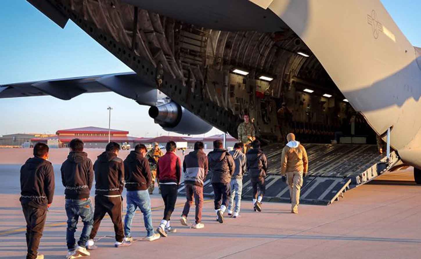 Men in shackles being led on to a military plane to be deported to a third country by the Trump Regime.