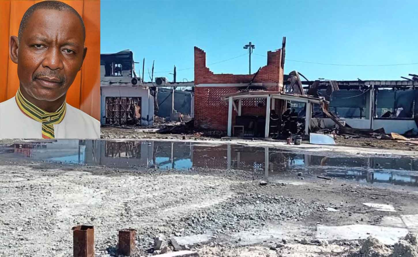  General Secretary of the Guyana Trades Union Congress Lincoln Lewis  and the burnt out remains of the GTUC  headquarters. 