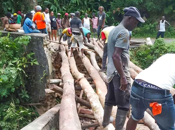 Residents changing the wood used to cover the chasm resulting from the broken down Woodsville Bridge in Eastern Hanover.