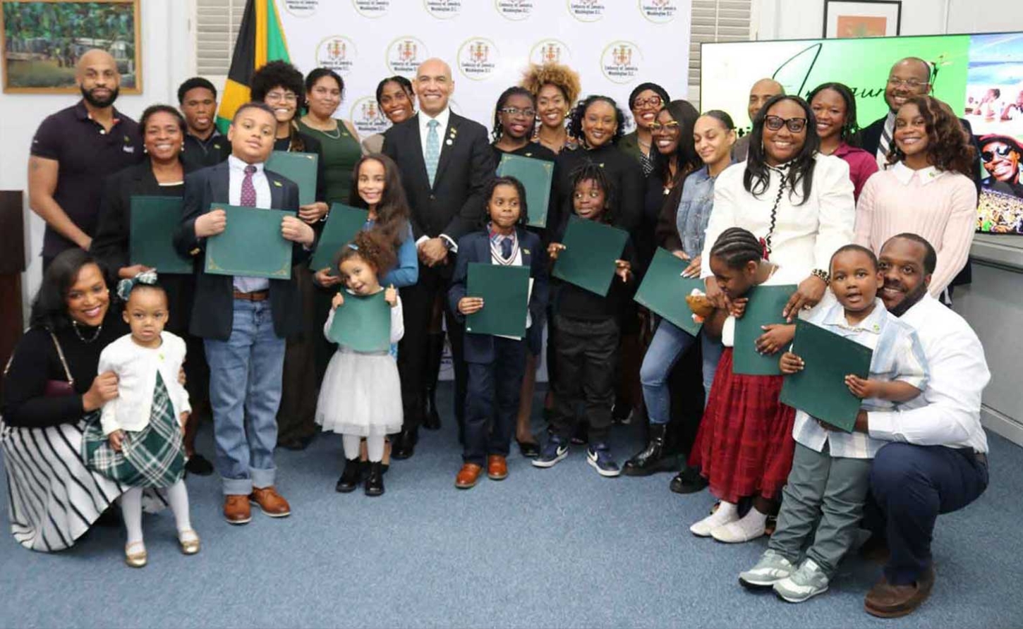 New Jamaican Citizens display their Certificatde of Citizenship at a ceremony on Friday, March 27, at the Embassy of Jamaica in Washington, D.C. , which formally recognized 27 Jamaican nationals — newly naturalized and those formalizing citizenship by descent. At centree is Ambassador His Excellency Antony Anderson, Jamaica’s Ambassador to the United States and Permanent Representative to the OAS who presided over the ceremony| Derrick Scott Photo