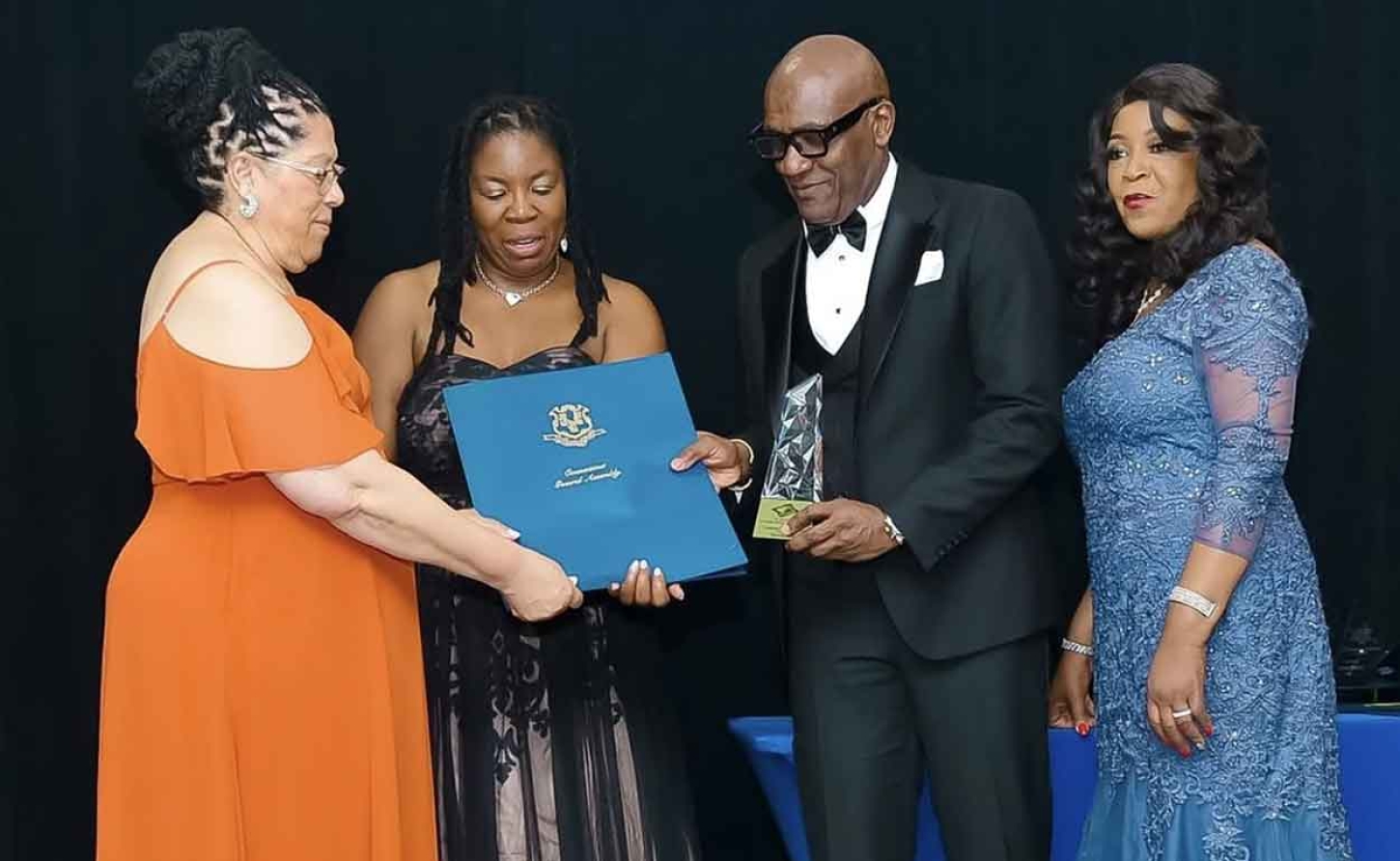 Information Attaché at the Embassy of Jamaica Derrick Scott (center) receives the 2026 Community Service Award and citation from West Indian Social Club of Hartford President Beverly Redd (left), assisted by Vice President Tanya Dorman and Claudett Graham, during WISCOH’s 76th Anniversary Gala in Hartford, Connecticut, on Saturday, April 18, 2026.
