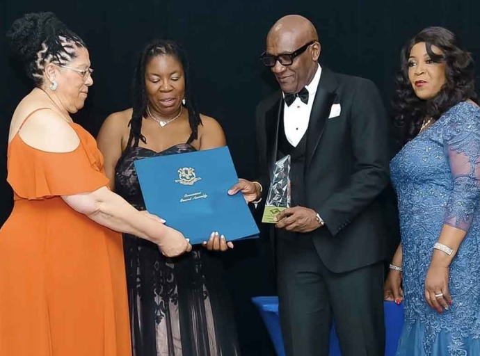 Information Attaché at the Embassy of Jamaica Derrick Scott (center) receives the 2026 Community Service Award and citation from West Indian Social Club of Hartford President Beverly Redd (left), assisted by Vice President Tanya Dorman and Claudett Graham, during WISCOH’s 76th Anniversary Gala in Hartford, Connecticut, on Saturday, April 18, 2026.