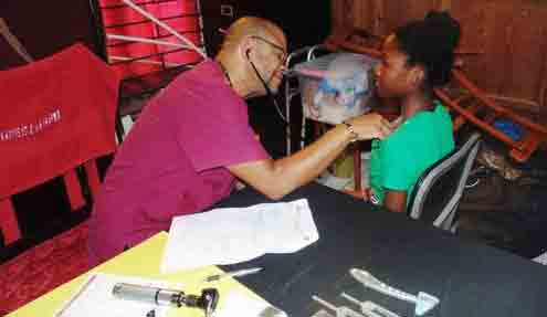 Dr. Chappy examines a young patron of one of the several health fairs prior held to assist parents prior to to the start of the new school year.