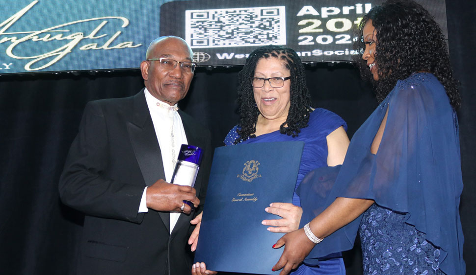 Former president of the New Jersey based Help Jamaica Medical Mission Dr. Rudolph Willis receives an award from the President of the West Indian Social Club of Hartford Ms Beverley Redd for his outstanding service to health care, at the 74th Anniversary gala of the West Indies Social Club of Hartford, Connecticut on April 20, 2024 at the club’s main street complex in Hartford. At right is Ms Marcia Anderson-Esson.