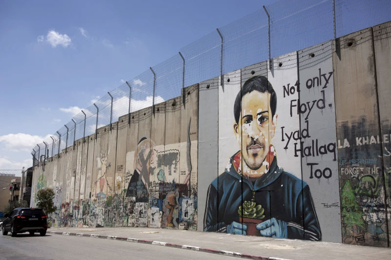 FILE - A mural depicting Eyad Hallaq, an autistic Palestinian man who was killed by Israeli police in Jerusalem’s Old City last year, is seen on Israel’s controversial separation barrier, in the West Bank town of Bethlehem, Friday, April 9, 2021. (AP Photo/Maya Alleruzzo, File)