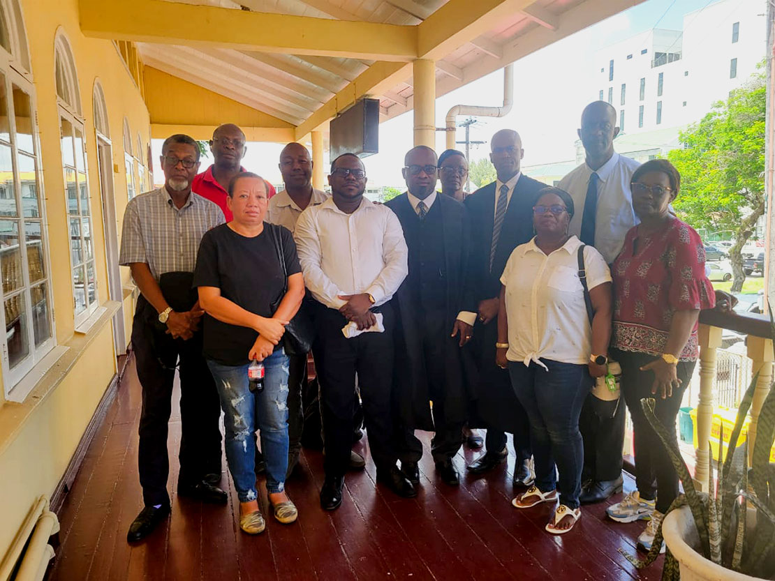 Senior Counsel Roysdale Forde and attorney Christopher Thompson pose for photographs with following the Chairman Trevor Benn and members of the Executive of the Guyana Public Service Co-operative Credit Union following the High Court decision.