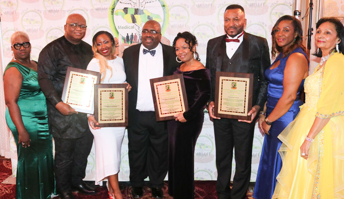 President of Help Jamaica Medical Mission, Dr. Robert Clarke center shares the spotlight with Help Jamaica Medical Mission awardees from second left Dr. Andrew Baddoo Dr Mercy Otieno Sonya Goodrich and Patrick Reid at the organization’s 13th annual black-tie gala, at the Hanover Manor in New Jersey on Saturday the 11th of Novembre. Also sharing in the moment from left are secretary of Help Jamaica Medical Mission Margarete Douglas, Help Jamaica Medical Mission Director of Public Relations Celia O’Gilvie. And Help Jamaica Medical Mission Vice President Angella Jones-Palmer. (PHOTO Derrick Scott)