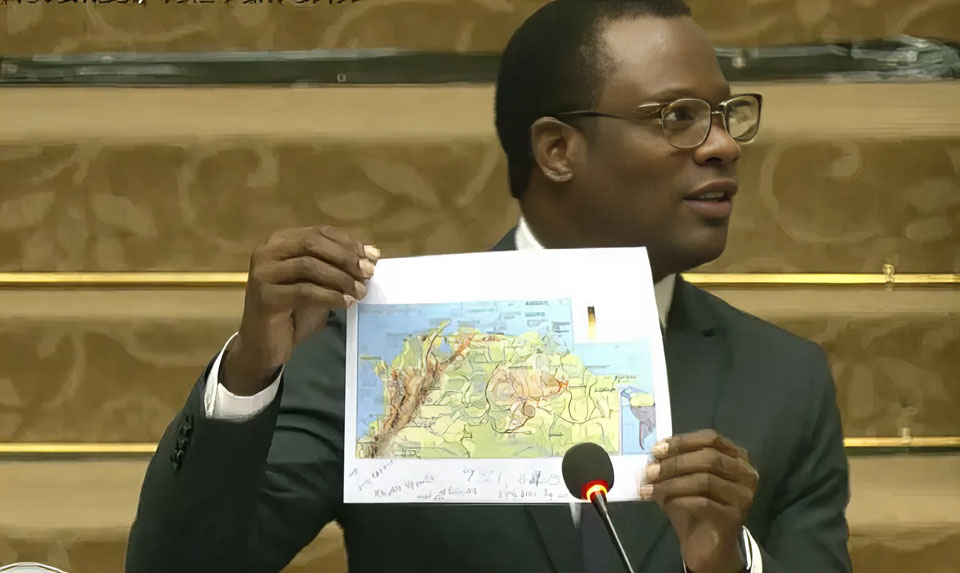 Foreign Affairs Minister Hugh Todd holding a map of northern South American that includes the internationally recognised boundary of Guyana | Demerara Waves