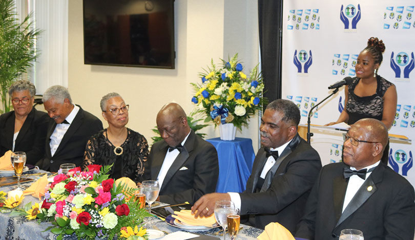 Minister/Counsellor for Trade at the Jamaican Embassy in Washington  Ms Aliecia Taylor delivers remarks on behalf of Ambassador Audrey Marks at the launch of the Northern Caribbean University’s International Development Foundation (NCUIDF) on Sunday April 28, at the Atrium Sligo Seventh Day Adventist Church at Takoma Park Maryland. Seated from left are: Mrs. Ruth Rutherford; Dr. Patrick  Rutherford, Executive Director of the Foundation; Mrs. Yvonne Melbourne; Foundation Board Chairman Dr. Bertram Melbourne; Treasurer, Seventh-Day Adventist World, Pastor Paul Douglas; President of NCU, Dr. Lincoln  Edwards, and retired Judge of the Court of Canadian Citizenship, Dr Pamela Appelt. 