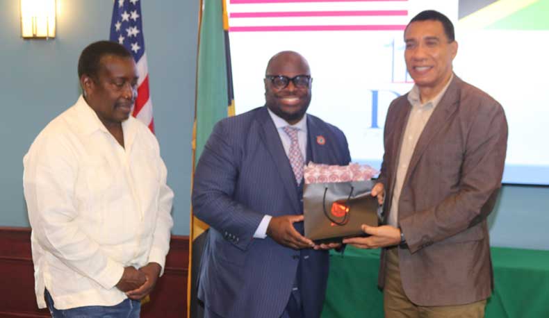 Prime Minister Andrew Holness accepts a gift  from The President of Delaware State University Dr. Tony Allen on Thursday at a luncheon given in his honour by the University. At left  is Member of Parliament for St Mary Western, Robert Montague | Derrick Scott Photo..