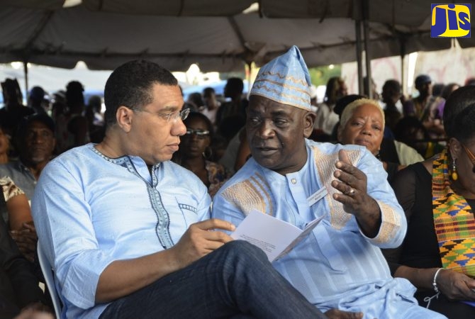 Prime Minister, the Most Hon. Andrew Holness (left), listens attentively to Colonel of the Accompong Town Maroons, Ferron Williams (right), at a celebration to commemorate the 281st celebration of the signing of the peace treaty with the British, and the birthday of their past leader, Cudjoe, in Accompong Town, St. Elizabeth, on Sunday, January 6, 2019 | JIS Photo by Avair Nembhard