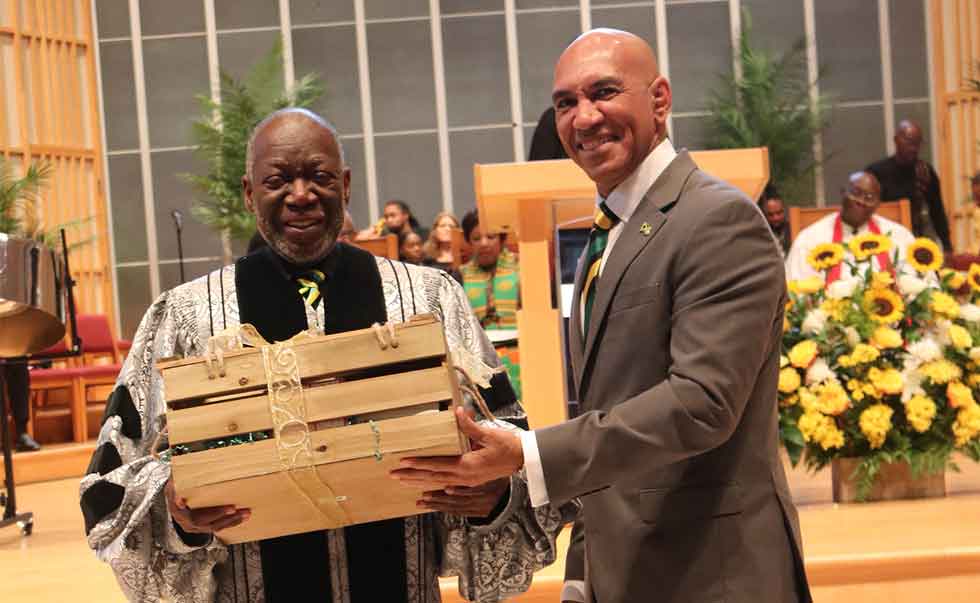 Dr. Bertram Melbourne being presented with a gift by Ambassador Antony Anderson for his more than thirty years in organizing Jamaica's independence service on behalf of the Jamaican embassy in Washington DC.