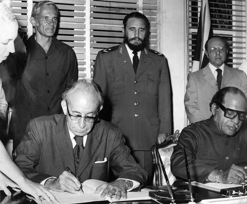 Cuba’s Minister of Foreign Affairs. Sr. Raul Roa (left) and Jamaica’s Minister of State for External Affairs Senator Dudley Thompson signing the economic and cultural agreements between Cuba and Jamaica at Protocol House in Havana on Saturday, July 12, 1975. Witnesses to the signing were Jamaica’s Prime Minister Michael Manley (standing left). Cuba’s Prime Ministers, Dr Fidel Castro and the Permanent Secretary in Jamaica’s Ministry of External Affairs, Mr Gordon Wells .