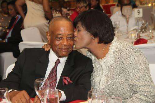 Former MP and minister of government Derrick Kellier being congratulated by former prime minister Portia Simpson Miller. 