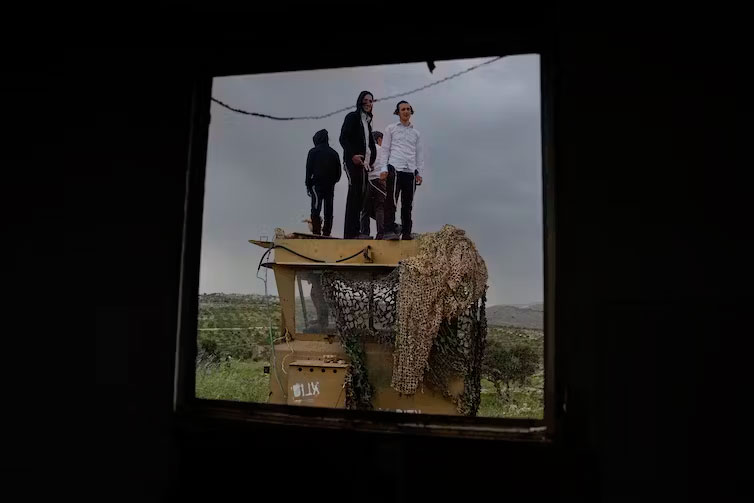  Israeli settlers stand in the outpost of Eviatar in the West Bank in April 2023. Ariel Schalit/AP 