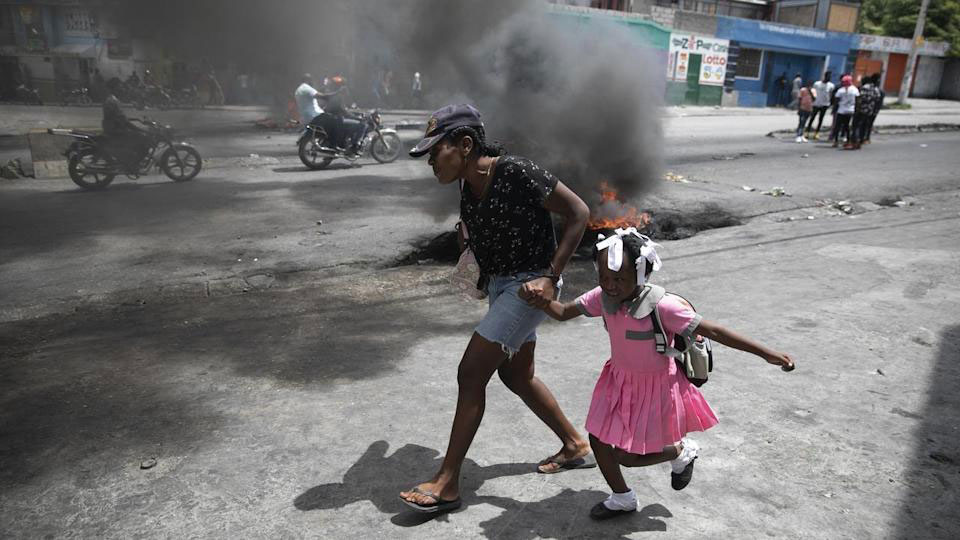 Mother and daughter flee to avoid the marauging gangs fighting in the Haitian Capital. 