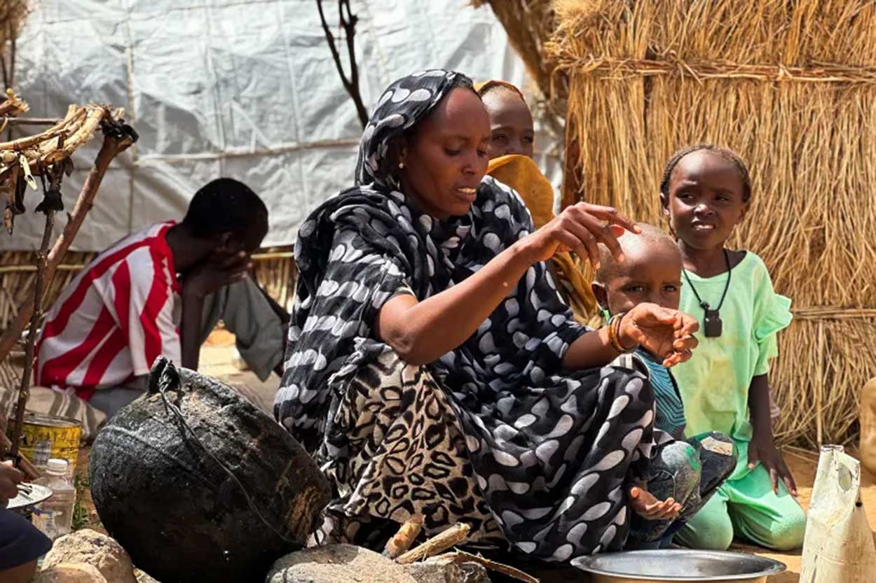 Houda Ali Mohammed, 32, a displaced Sudanese mother of four, prepares food at a camp in Tawila, North Darfur, Sudan, during the war between the paramilitary Rapid Support Forces and the Sudanese army [File: Mohamed Jamal/Reuters]