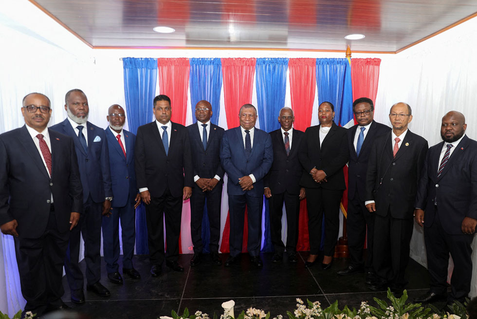 Michel Patrick Boisvert, center, who was named interim prime minister by the cabinet of outgoing Prime Minister Ariel Henry, smiles after posing with members of a transitional council tasked with selecting Haiti's new prime minister and cabinet, in Port-au-Prince, Haiti, Thursday, April 25, 2024. Boisvert was previously the economy and finance minister. (AP Photo/Ramon Espinosa)