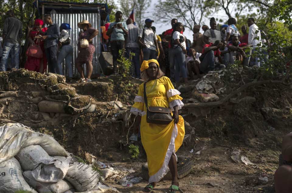 A Voudist clad in yellow, a color associated with the power of light, poses for a photo during the Saint George celebration in Port-au-Prince, Haiti, April 24, 2024. (AP Photo/Ramon Espinosa, File)